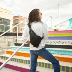 A man wearing the smell proof cross body bag over his back