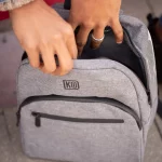 Someone opening the Grey Smell Proof Backpack